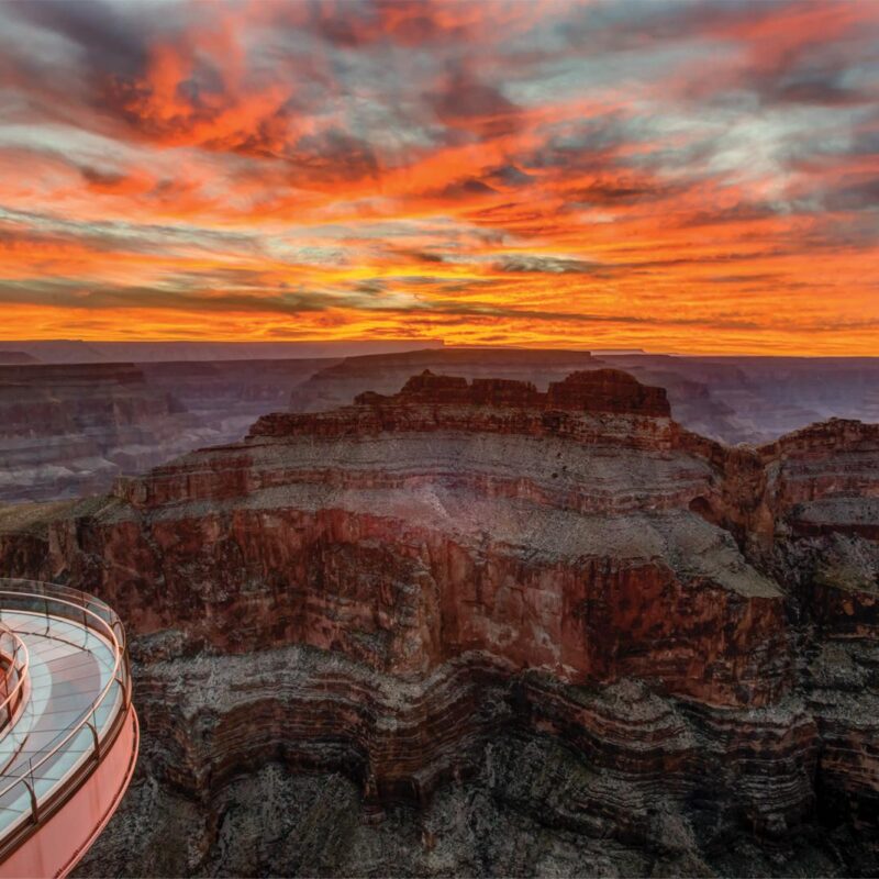 Grand Canyon at sunset with dramatic orange sky and the Skywalk.