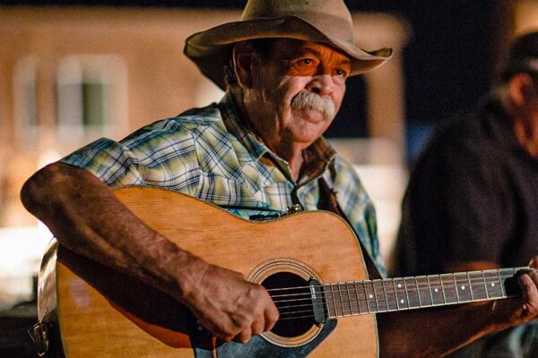 牧场 美国原住民男子在牧场篝火旁弹吉他。.