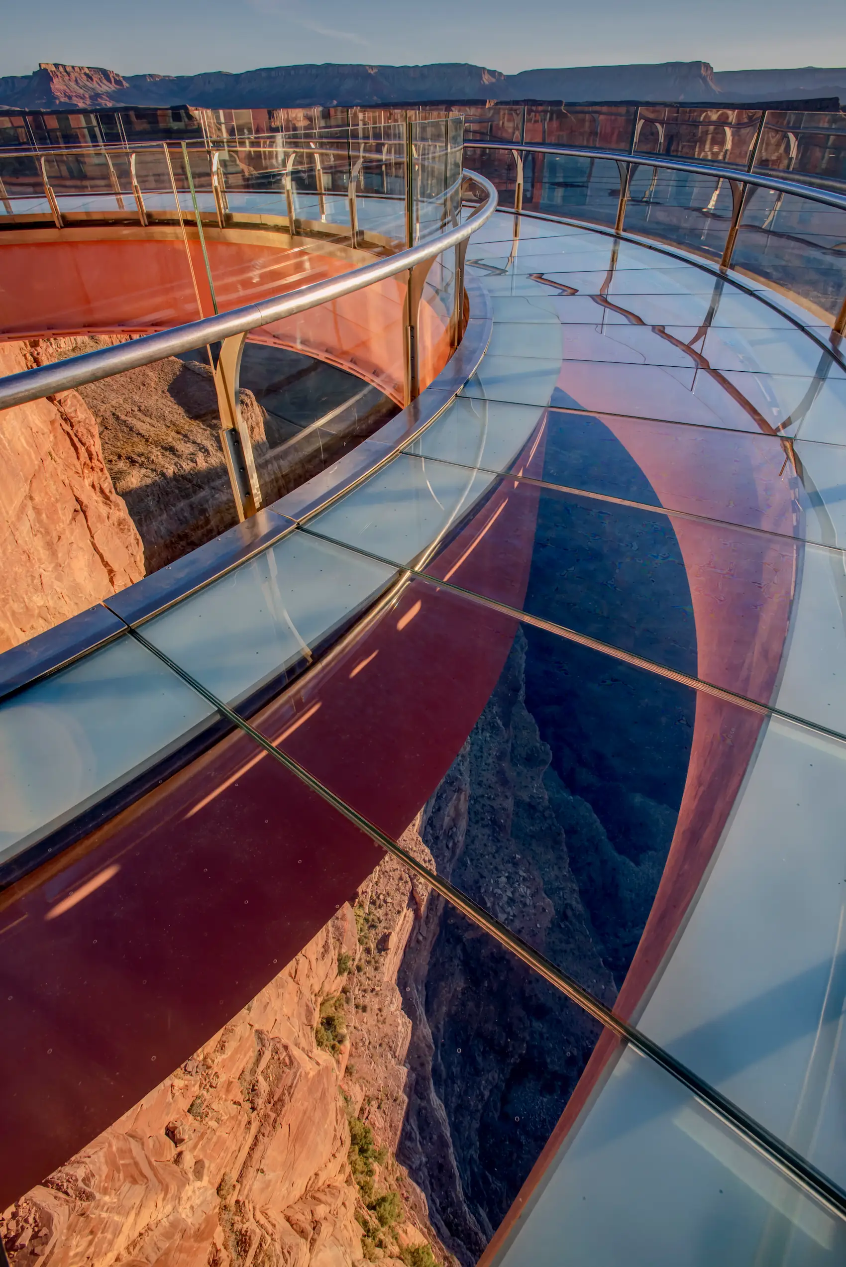 Skywalk Highlight Detailed perspective of the Grand Canyon Skywalk’s glass-bottom walkway with steel railings, reflecting canyon walls and deep gorge below.