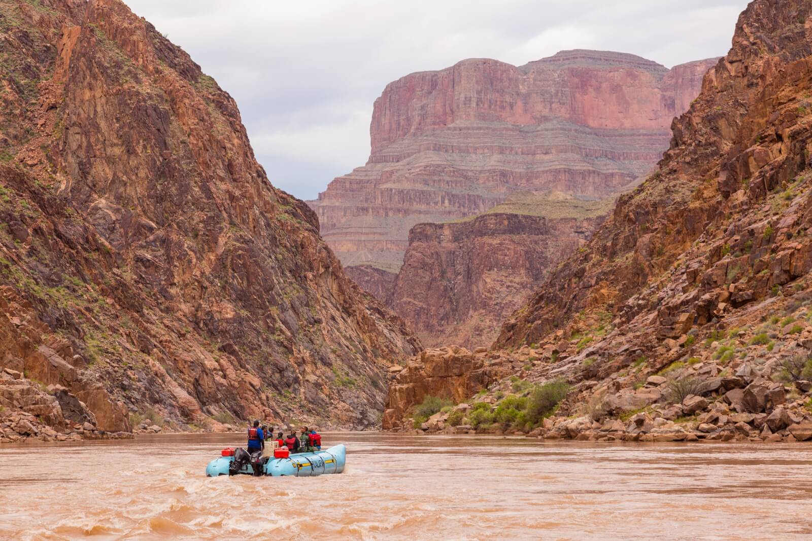 A small group of river rafters look at the canyon walls along the Colorado River