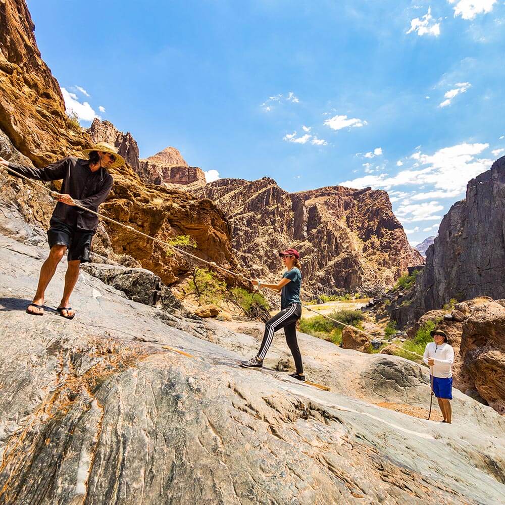 Three people hiking up mountain in Grand Canyon West