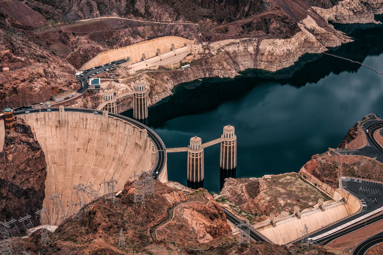 The Ultimate Vegas to Grand Canyon Road Trip Itinerary High-angle view of the Hoover Dam and the dark blue water of Lake Mead.